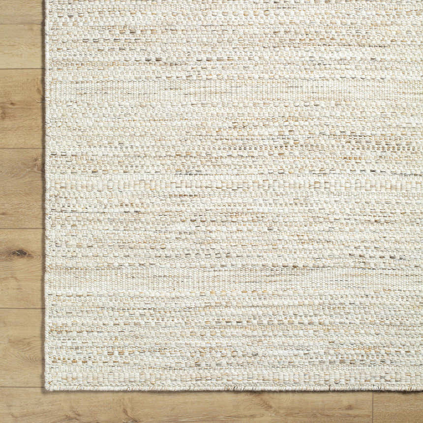 Close-up of the hand woven Moshe Area Rug. Peach wool rug with a farmhouse, traditional, transitional style. Corner