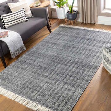 Living room scene with charcoal sofa and the Morrisburg Wool Tassel Carpet in charcoal and cream on hardwood floors. Roomscene-Rectangle