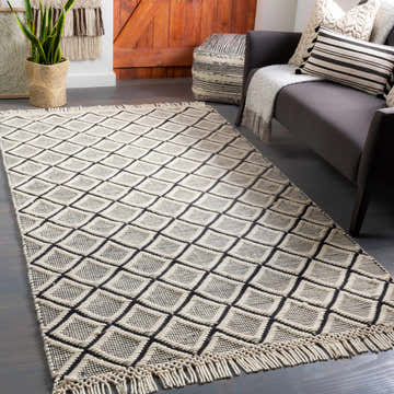 Living room scene with gray sofa and Maria Textured Hand Woven Wool Rug in black and cream with geometric diamond pattern. Roomscene-Rectangle