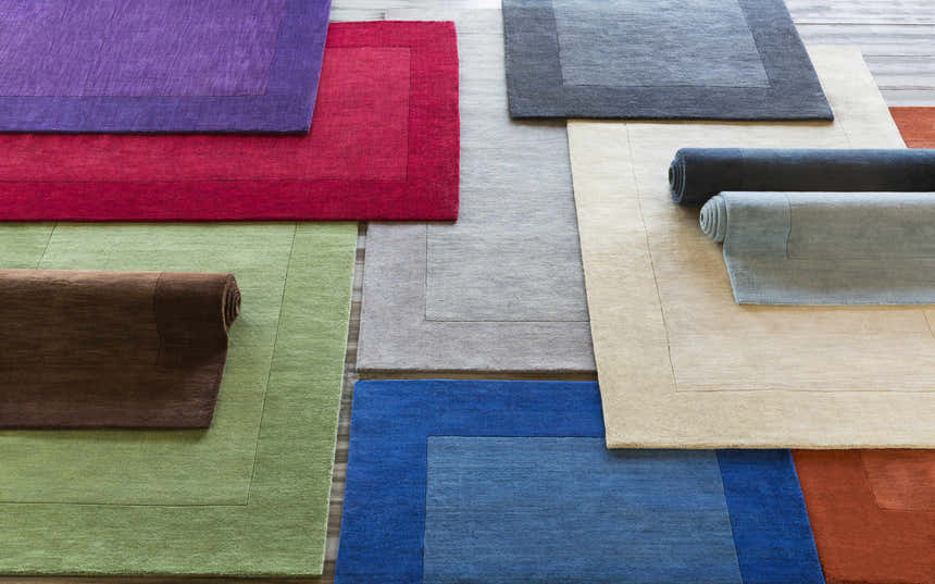 Variety of colorful Bordered Solid Wool Rugs in purple, red, green, brown, gray, blue, beige, and rust. Styleshot