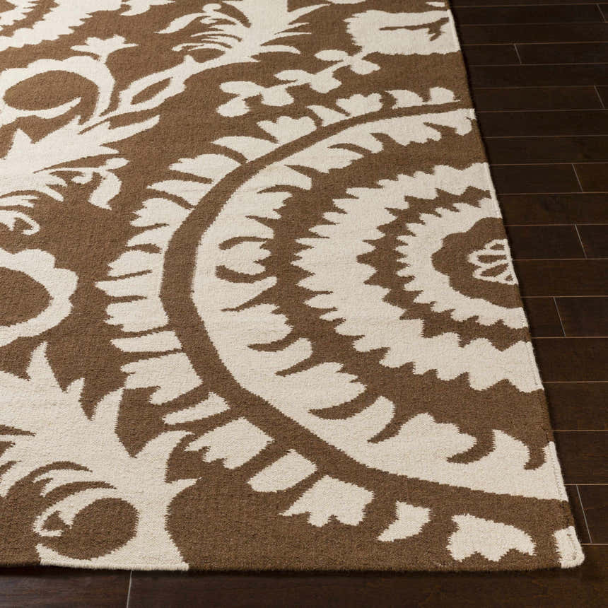 Close-up of the hand woven Naeva Area Rug. Dark brown and walnut floral pattern on a rectangular wool rug. Front
