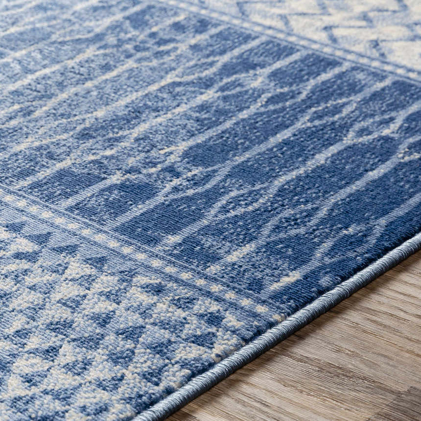 Close-up of the Nampa Area Rug showing its denim and ivory contemporary pattern and machine-woven texture. Texture