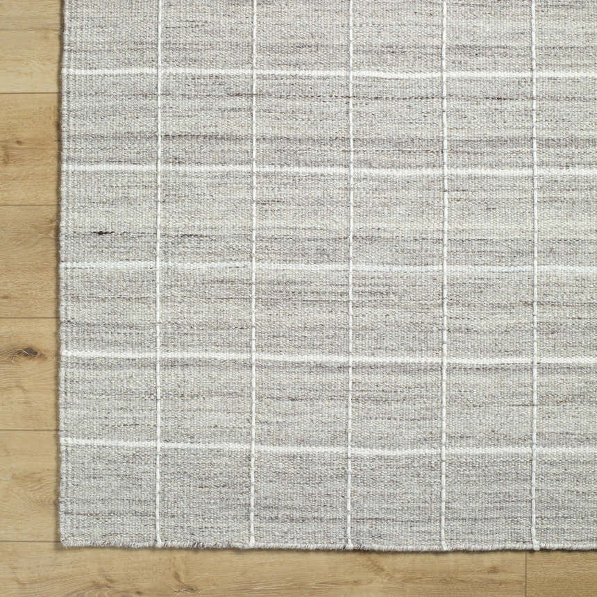 Close-up of the hand woven Nissa Checkered Area Rug. Light gray, medium gray, and off-white wool with a subtle checkered pattern. Corner