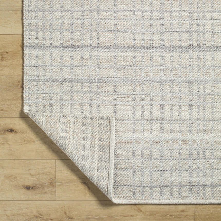 Close-up of the hand-woven Nissa Tan Area Rug showing ivory and tan colors, horizontal stripes, and wool texture. Fold