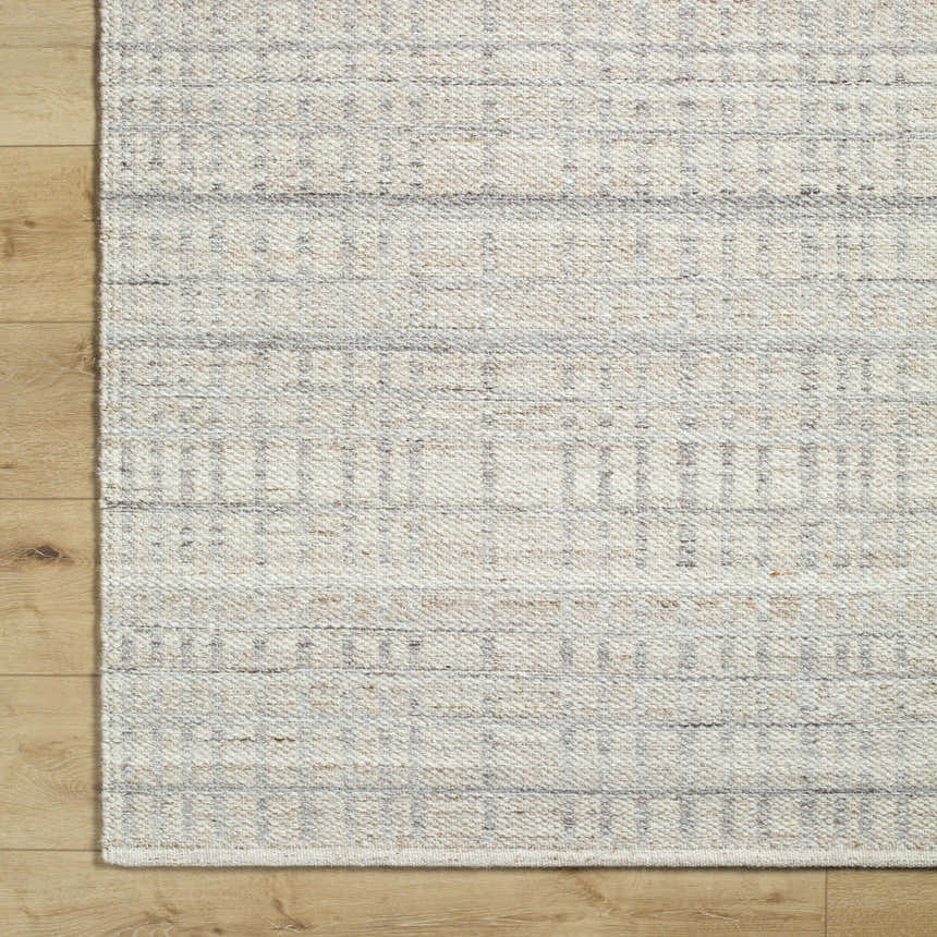 Close-up of the hand woven Nissa Tan Area Rug. Ivory and tan wool rug with subtle geometric pattern and texture. Corner