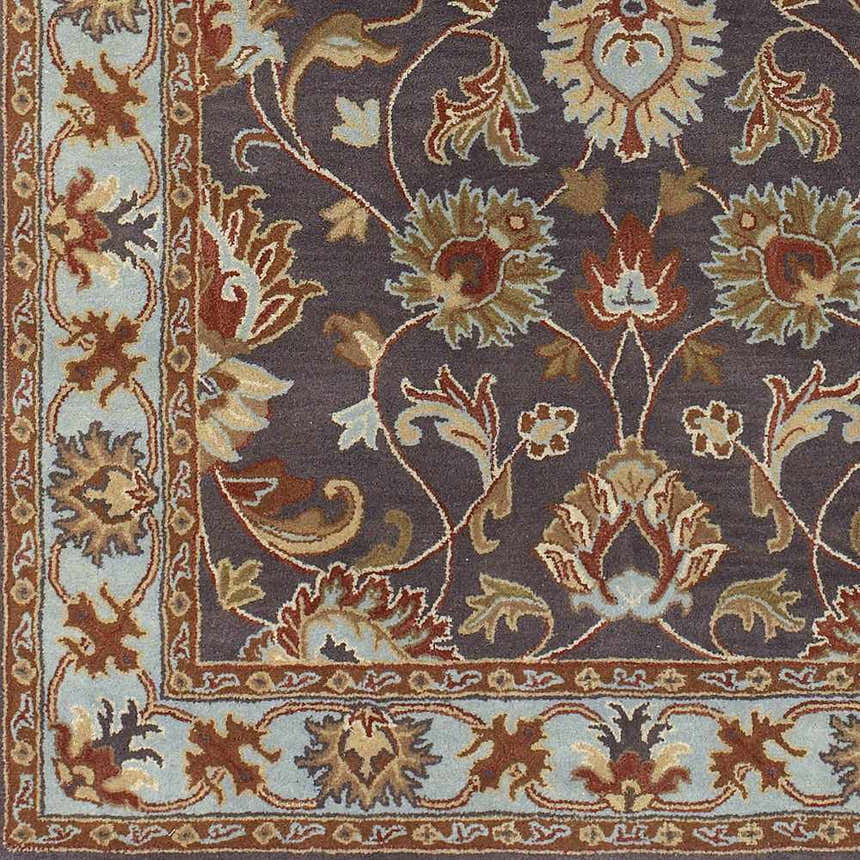Close-up of the Cherryfield 1004 rug. Hand tufted wool rug with floral pattern in beige, burnt orange, slate, and ice blue. Texture