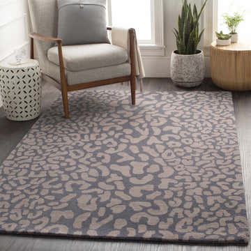 Cozy reading nook with a gray armchair and the Neoma Animal Print Wool Rug in gray and beige. Roomscene-Rectangle