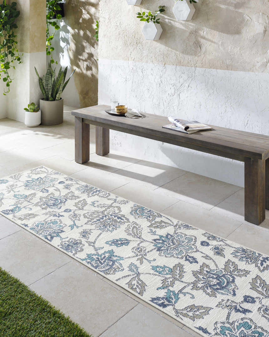 Bright sunroom with a wooden bench and a floral Neon Area Rug in navy, blue, and white. Roomscene-Runner