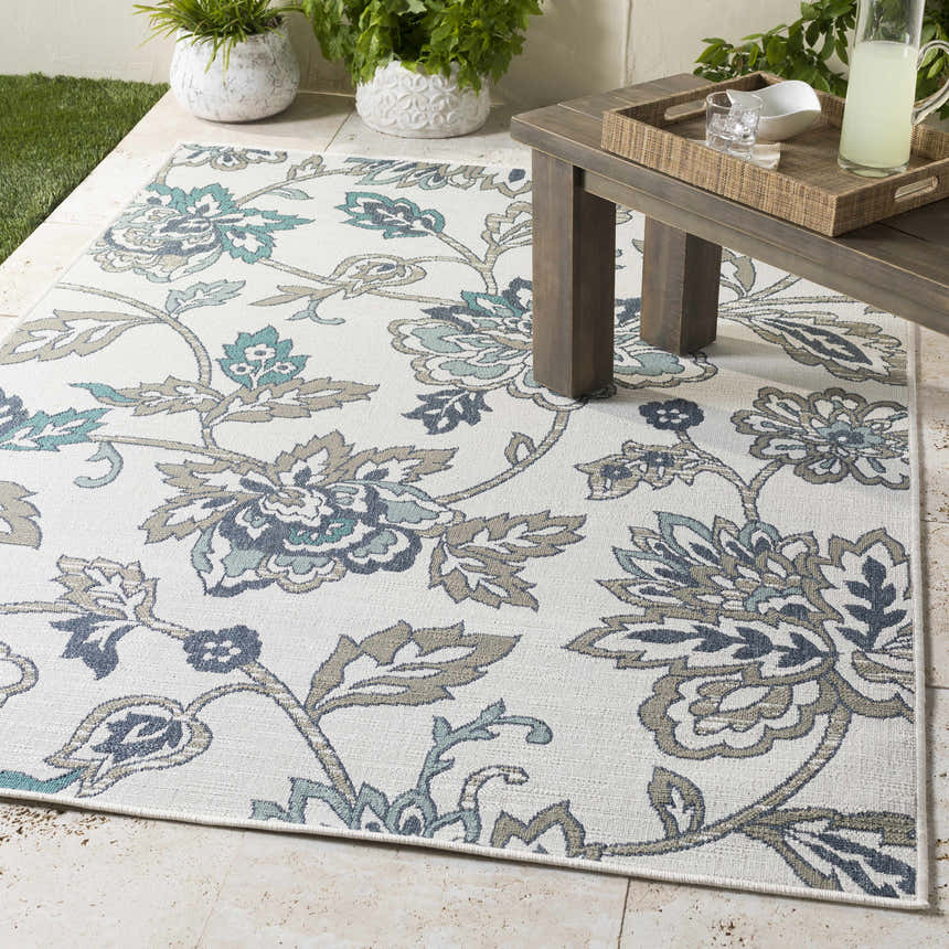 Outdoor patio scene with a white Neon Area Rug featuring navy, teal, and taupe floral patterns. Roomscene-Rectangle