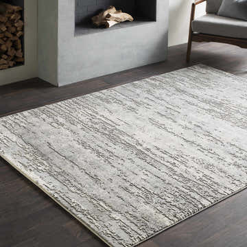 Living room scene with a gray Nesmith Updated Traditional Tibetan Rug, fireplace, and modern chair. Roomscene-Rectangle