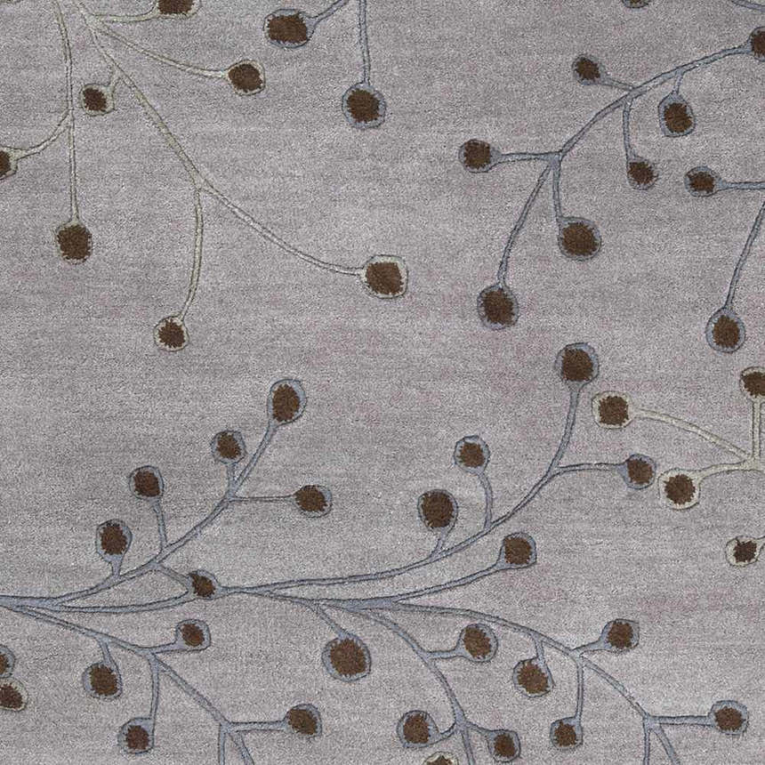 Close-up of the Sage Brown Elsu Area Rug showing its floral branch pattern in brown and sage on a gray wool texture. Swatch
