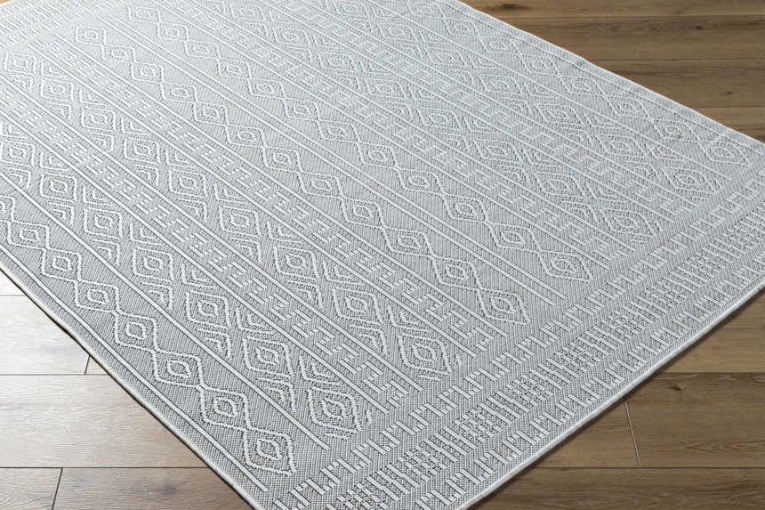Close-up of the Nuela Light Gray Area Rug showing its diamond and line pattern and woven texture on a wood floor. Corner