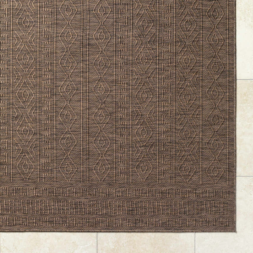 Close-up of the Nuela Dark Brown Area Rug showing its diamond and geometric pattern and woven texture. Corner