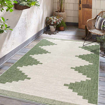 Outdoor patio scene with a Djugun Green Performance Rug, wood floors, plants, and a wicker chair. Roomscene-Rectangle