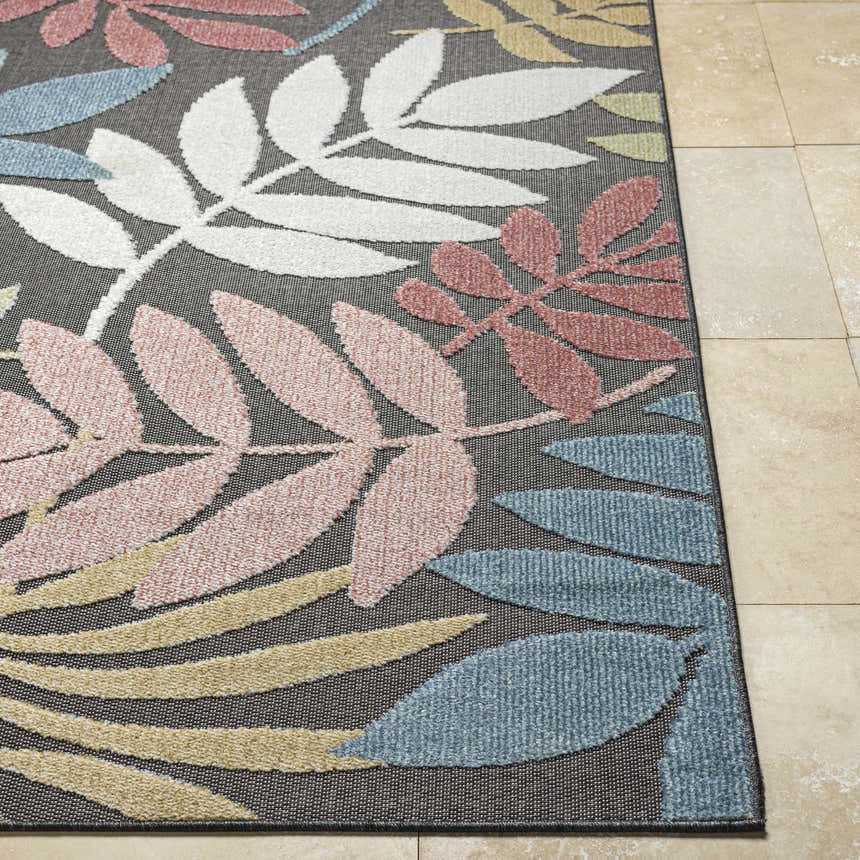 Close-up of the Nasha Charcoal Area Rug with a leaf pattern in blue, dusty pink, mustard, and white. Coastal style. Front