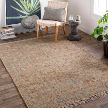 Farmhouse style room with a Rice Dusty Sage Fringed Jute Carpet, woven chair, and potted plant. Roomscene-Rectangle