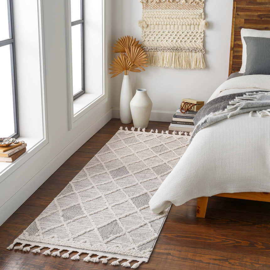 Bedroom scene with a gray and ivory Norvelt High/Low Pile Rug with Tassels, wood floors, and neutral decor. Roomscene-Runner