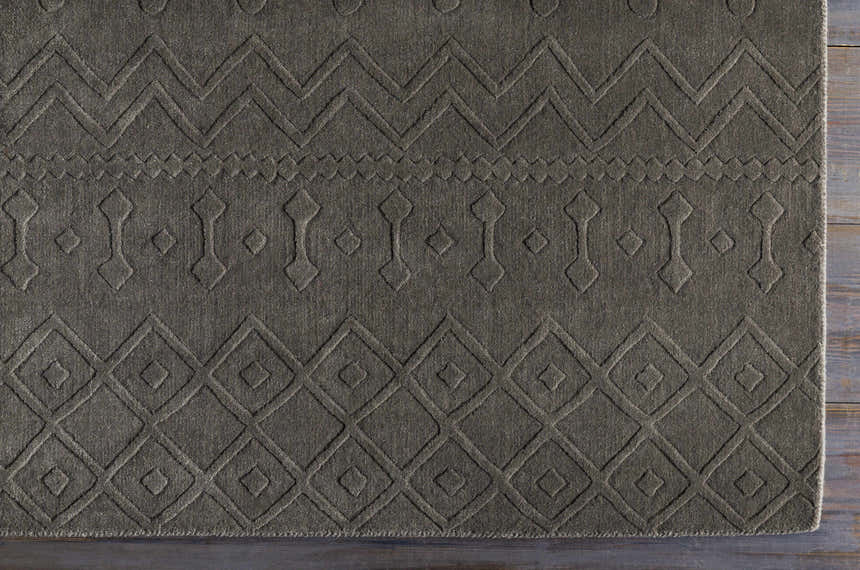 Close-up of the charcoal Newtonhill Clearance Rug, a hand-loomed wool rug with farmhouse-style geometric patterns. Corner