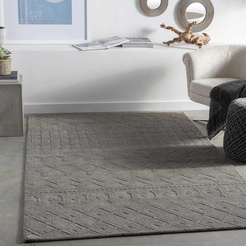 Living room scene with charcoal Newtonhill Clearance Rug, neutral chair, and modern decor. Roomscene-Rectangle