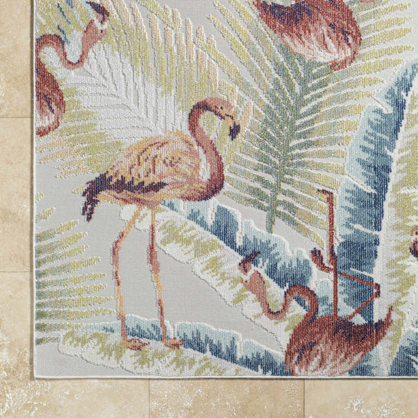 Close-up of Nayan Light Slate Area Rug featuring a flamingo and palm leaf design in blue, cream, and rust tones. Coastal style. Corner