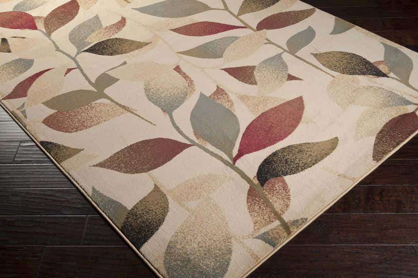 Close up of the Ober Fall Leaves Rug featuring a contemporary leaf pattern in red, brown, green, and black. Corner