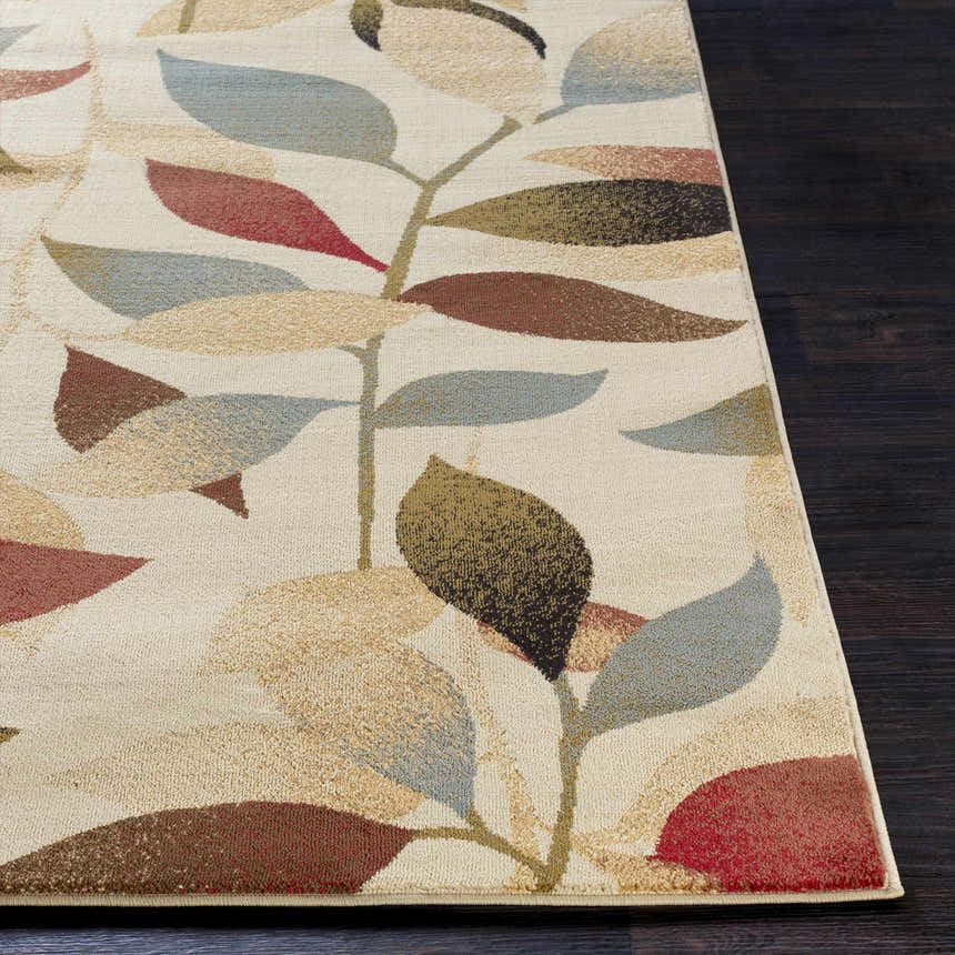 Close-up of the Ober Fall Leaves Rug. Machine-woven polypropylene rug with a leaf pattern in red, brown, green, and blue on a cream background. Front