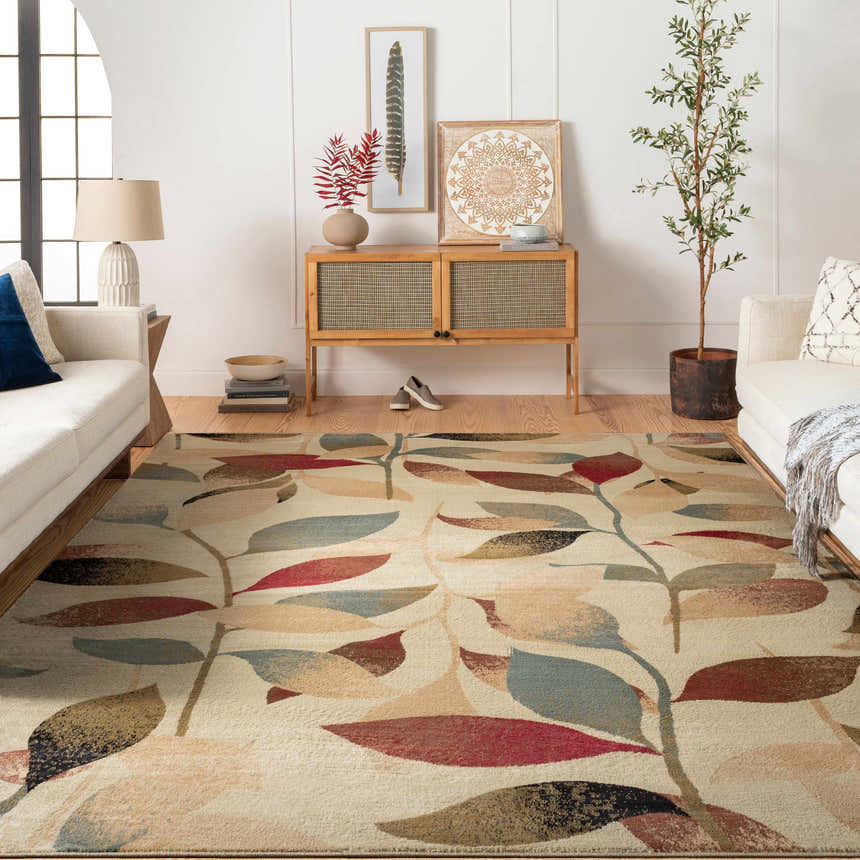 Living room scene with a neutral sofa and the Ober Fall Leaves Rug with red, brown, and green leaf pattern. Roomscene-Rectangle