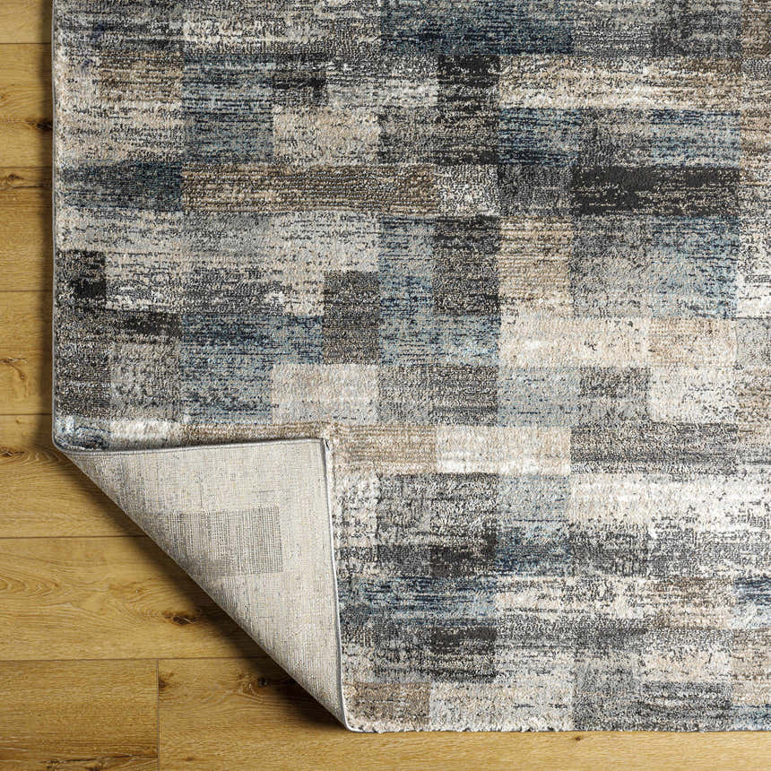 Close-up of Ohtli Mosaic Luxe Thick Area Rug showing gray, smoke, and blue tones in a Southwestern mosaic pattern. Fold