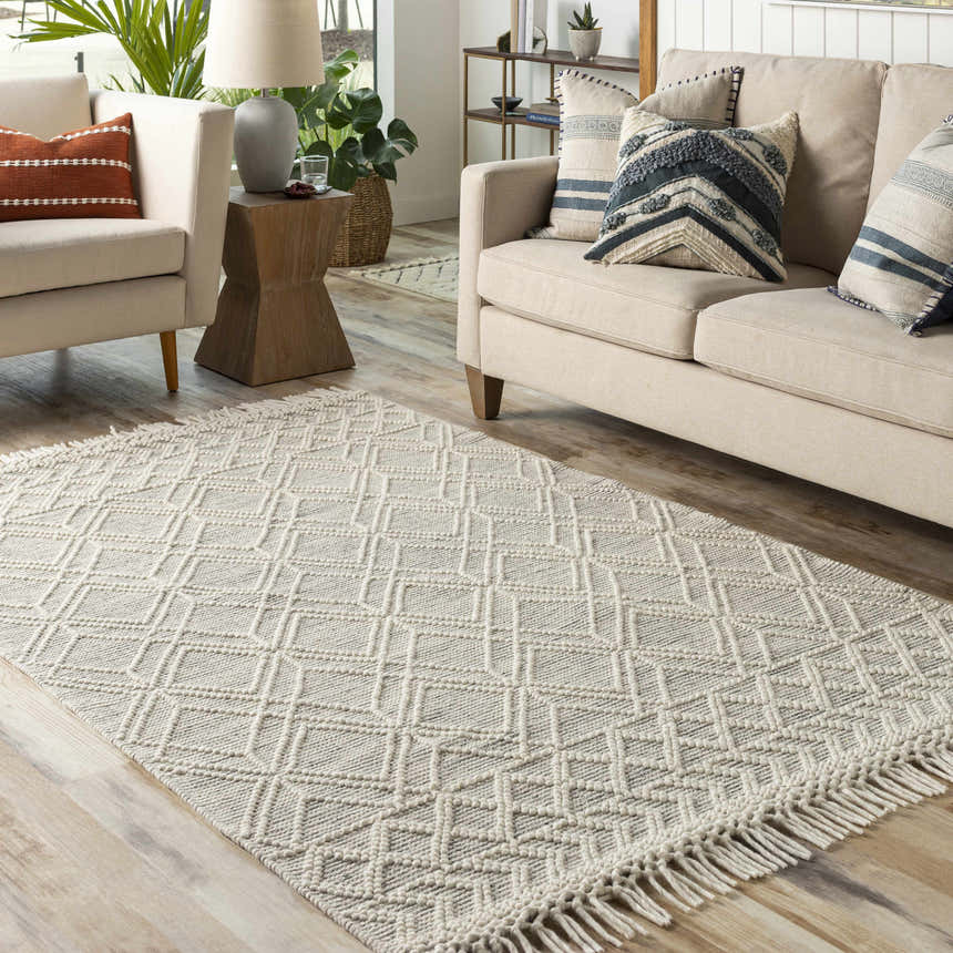 Living room scene with a cream sofa and the neutral Ossun Wool Rug with Tassels, showcasing a farmhouse style. Roomscene-Rectangle