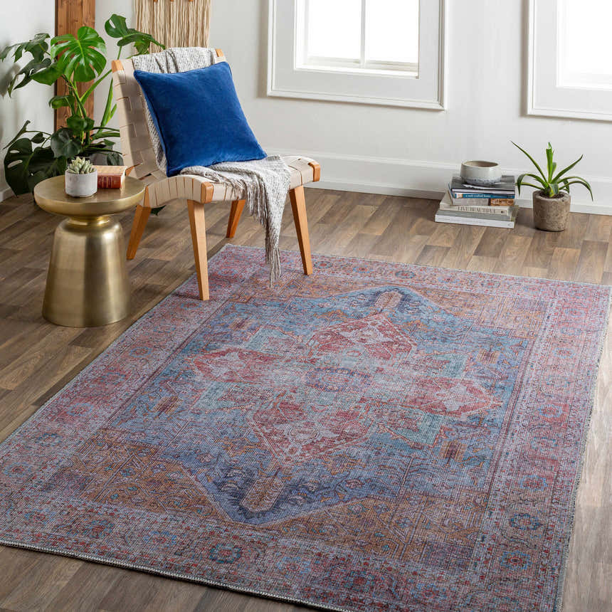 Living room scene with the Otaki Washable Area Rug in dark gray, purple, and brown, styled with a chair, side table, and plants. Roomscene-Rectangle