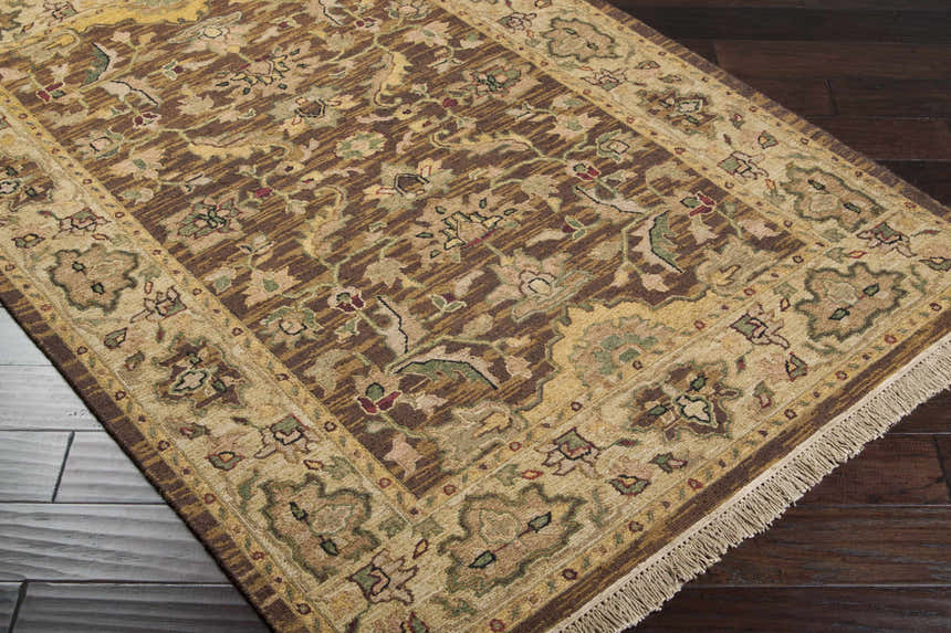 Close-up of the hand-knotted Palmview Area Rug. Beige, brown, and tan floral pattern with fringe detail. 100% NZ Wool. Corner