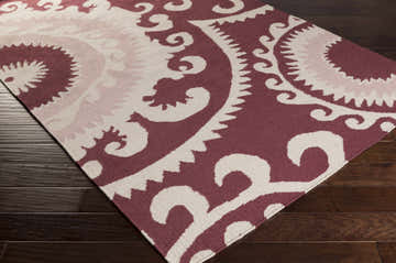 Close-up of the Panaca Area Rug showing its hand-woven texture and contemporary maroon and cream geometric pattern. Corner