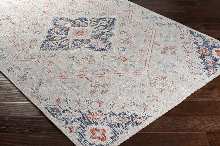 Close up of the Papineauville Area Rug featuring cream, blue, red, and saffron colors. Corner