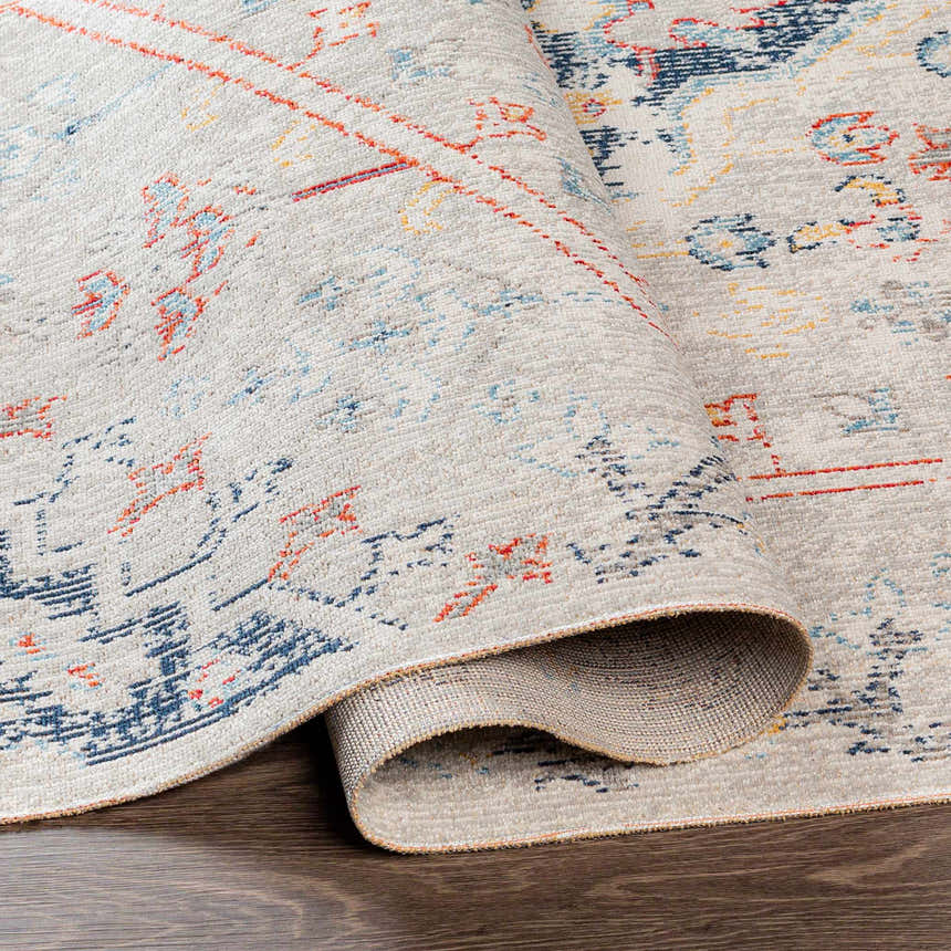 Close-up of the Papineauville Area Rug. Oatmeal rug with aqua, cream, dark blue, red, and saffron traditional pattern. Fold