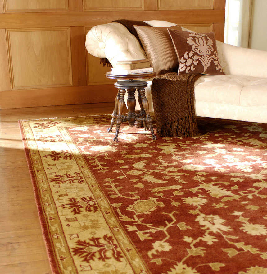 Traditional living room scene with a brick red Parkhill Area Rug, beige chaise lounge, and wooden accents. Roomscene-Rectangle