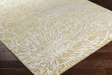 Close-up of the Patagonia Area Rug showing its light gray and mustard floral pattern and hand-knotted texture. Corner