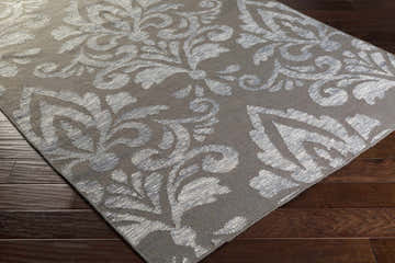 Close-up of the Pearsonville Area Carpet. Gray wool rug with a large, light gray traditional damask pattern. Corner