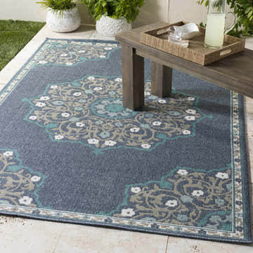 Outdoor patio scene with the navy Penland Area Rug, wood table, and pitcher of lemonade. Roomscene-Rectangle