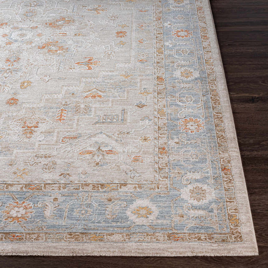 Close-up of the Phyllis Thick Luxe Statement Rug showing its light beige, blue, and orange traditional pattern. Front