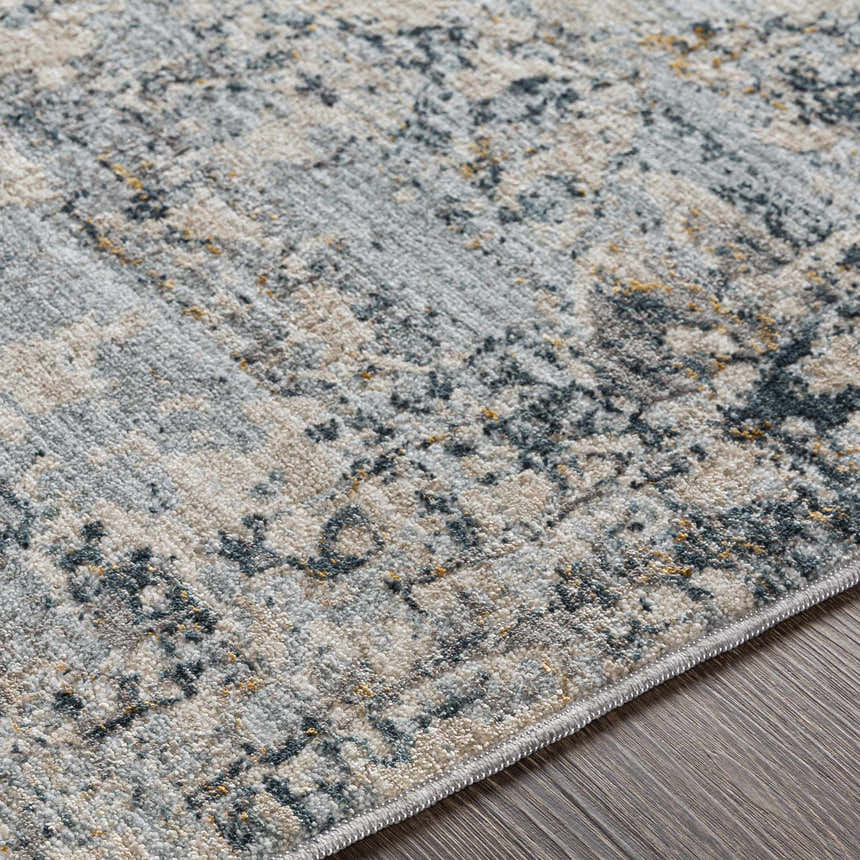 Close up of the Pinjarra Luxe Rug showing its charcoal, cream, gray, and blue contemporary pattern and soft polyester texture. Texture