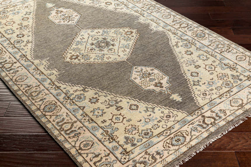Close-up of the hand-knotted Pinokawan Area Rug. Charcoal, beige, and denim wool rug with traditional oriental design. Corner