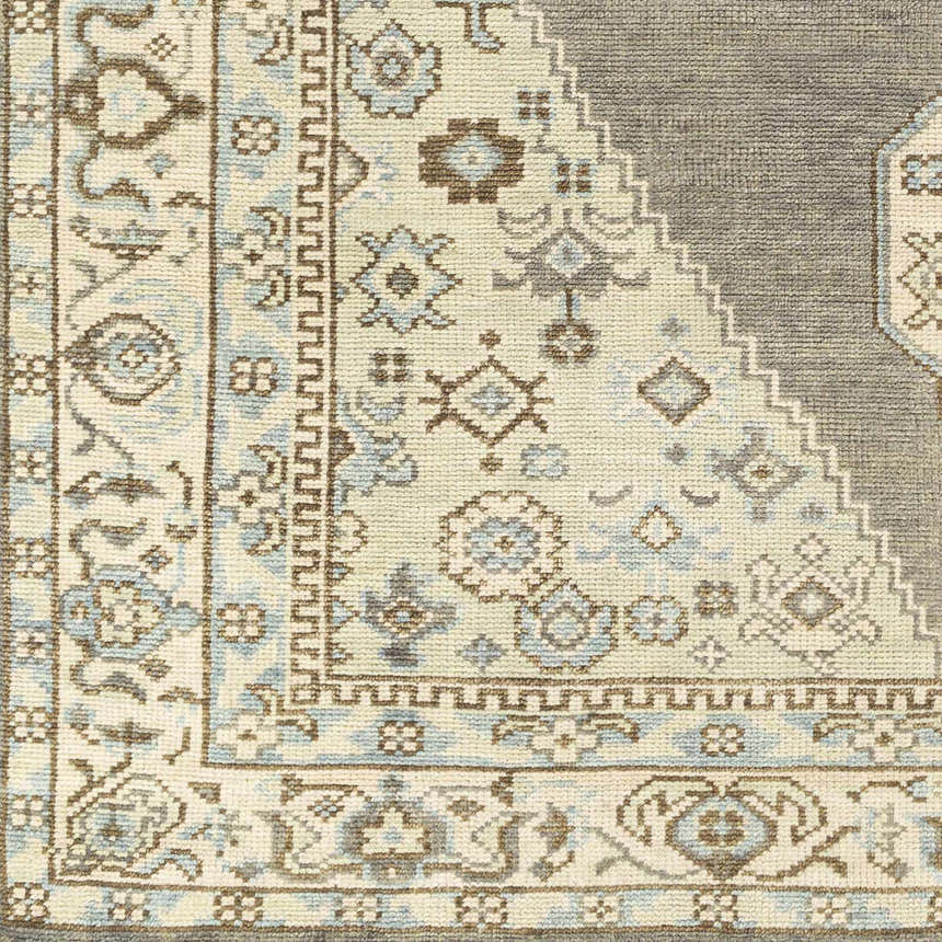 Close-up of the hand-knotted Pinokawan Area Rug. Charcoal, dark brown, denim, & light beige wool with a traditional pattern. Swatch