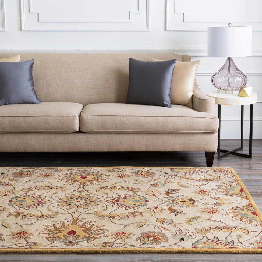 Living room scene with a floral Pirtleville Area Rug, beige sofa, gray pillows, and a marble side table. Roomscene-Rectangle