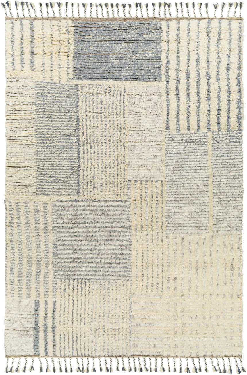 Close-up of the hand-knotted Plean Premium Rug. Features a geometric pattern in cream and charcoal wool with tassel details. Design-Rectangle-69