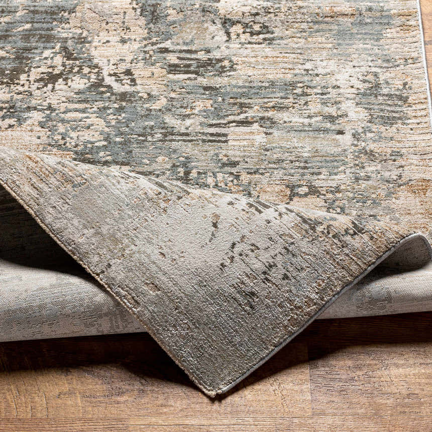 Close-up of the Palanit Thick Luxe Boutique Rug showing its gray, beige, and charcoal abstract design and soft texture. Fold