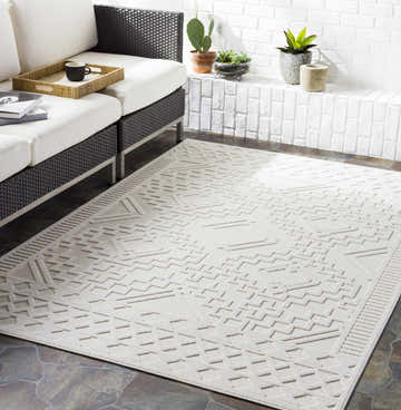 Modern patio with black wicker sofa and light beige Plumtree 3D White Outdoor Rug featuring a geometric pattern. Roomscene-Rectangle