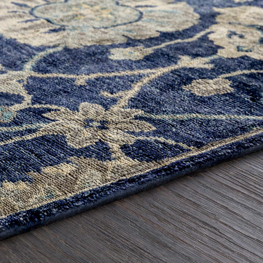 Close up of the Pinetop Premium Rug showing its navy, aqua, and oatmeal floral design and hand-knotted texture. Texture