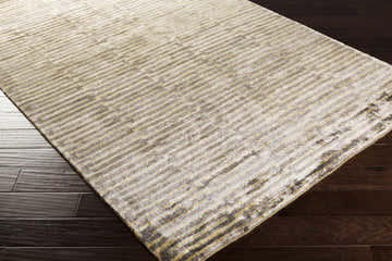 Close-up of Porthma Premium Viscose Area Carpet in camel, charcoal, and gray on dark wood floor. Contemporary striped design. Corner