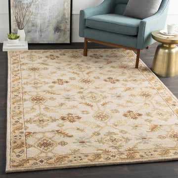 Living room scene with the Postelle Wool Rug. Beige rug with brown, sage, and red floral pattern under a blue chair. Roomscene-Rectangle