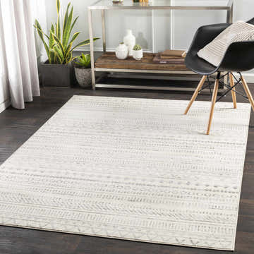 Living room scene with a Parmelia Area Rug in charcoal and gray tones, styled with a modern chair and console table. Roomscene-Rectangle